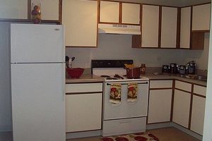 Kitchen, white cabinets with brown trim, white applicances
